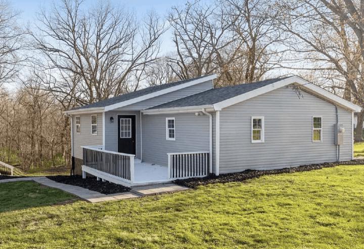 Gray ranch house with a white front porch bought by TruOffer