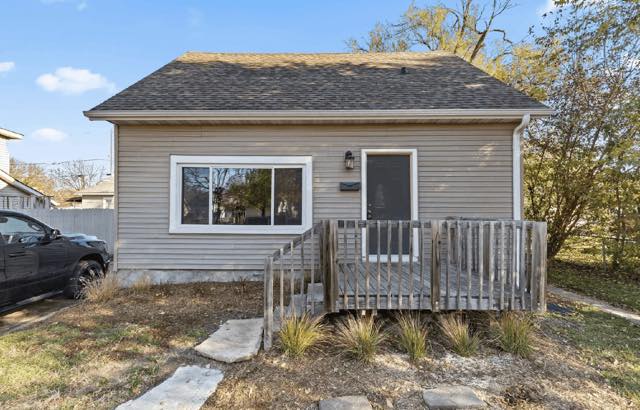 Tan house with a wooden front deck bought by TruOffer