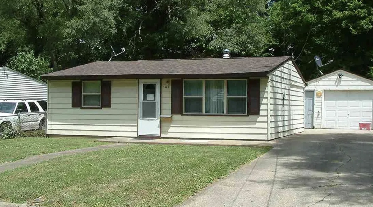 Cream ranch house with brown shutters and a detached garage bought by TruOffer